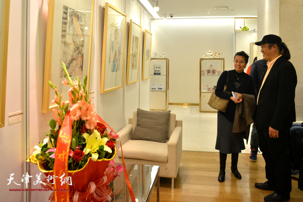 王刚与来宾在观赏展出的画作。