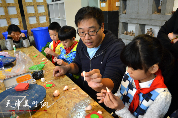 津派面塑传承人张亚杰教小学生们捏小猪。