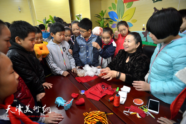 天津民间艺术家张金芳向小学生传授“赵氏布艺”。