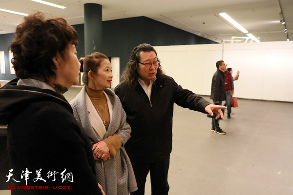 宋莉民、朱立、邓英彪在观看展出的作品。