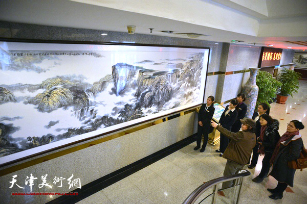 董振涛与大家欣赏巨幅山水画作《苍峰云瀑》前。