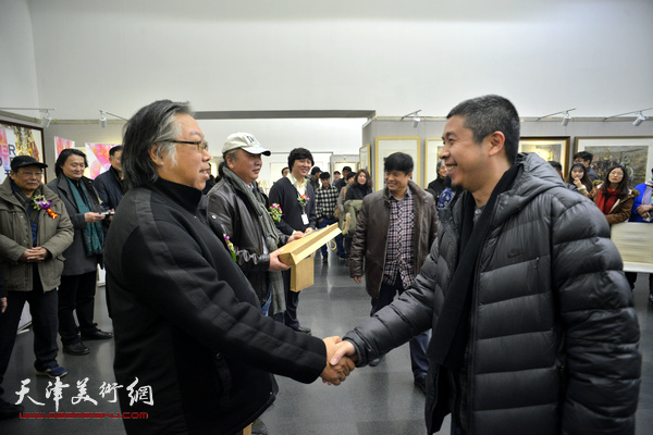 天津美协水彩画艺委会主任石增琇为银奖获得者胡景珲颁奖。