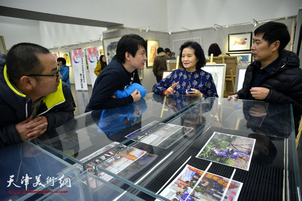 田同芬、张宝欣、李垚在画展现场交谈。