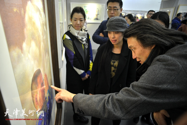 薛义、井旭在观赏展出的作品。