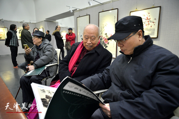 王俊生、庞黎明在阅读为此次画展出版的画集。