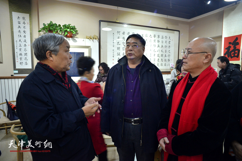 唐云来、张金忠、刘雪松在画展现场交流。