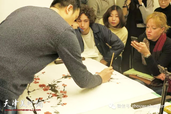 周午生为罗马美术学院学生讲授中国画梅、兰、竹、菊等传统题材的画法，图为在示范兰花画法。