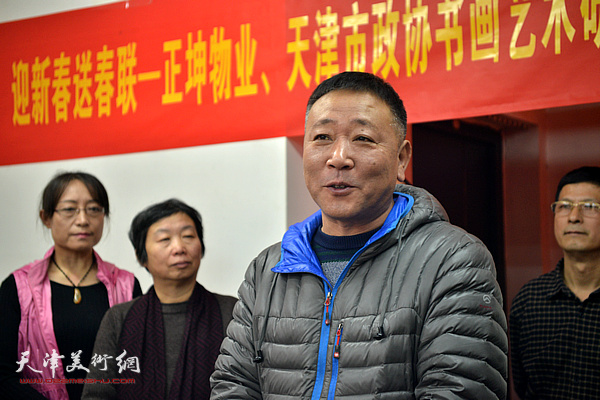 南市街办事处物业主任王志强欢迎艺术家走进社区迎春送福。