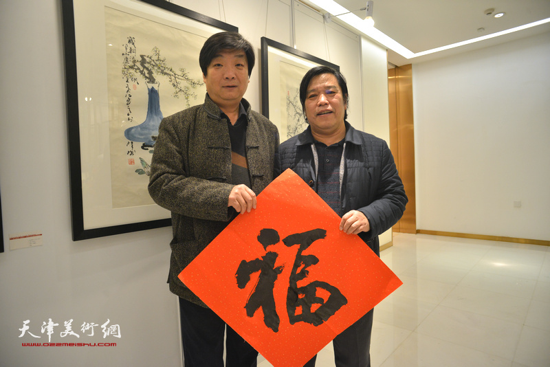 翟洪涛、李耀春在艺术沙龙展现场送“福”。