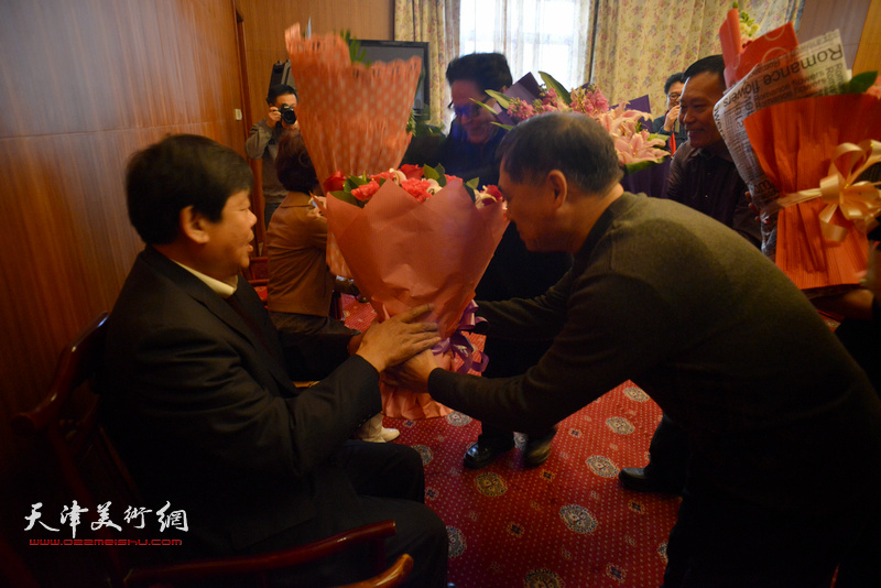 著名画家郭鸿春先生收徒仪式现场，新弟子向师父、师母敬献献花。