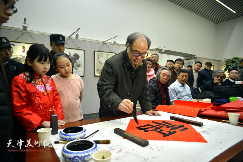 郭书仁在画展现场为观众送“福”。