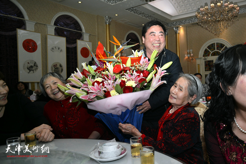 亲友为肖培金90高龄的老母亲高连荣送上献花。