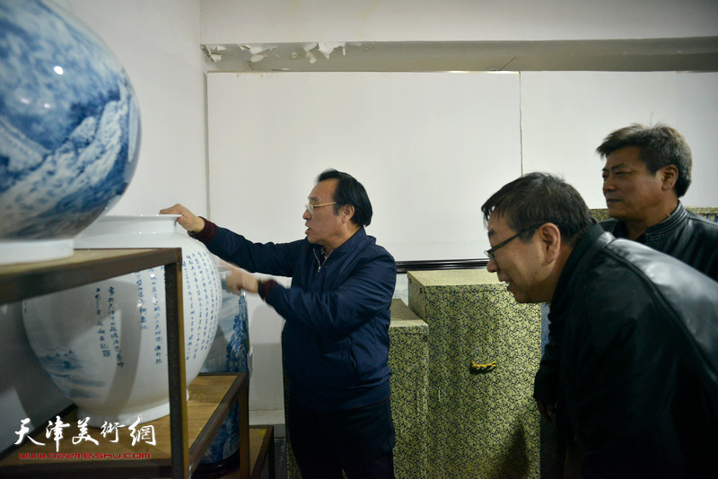陈钢向张运河、时景林介绍“长城青花瓷”系列作品创作。
