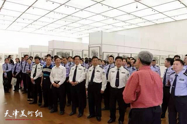 申世辉为青年警察在展览现场进行美育教育。