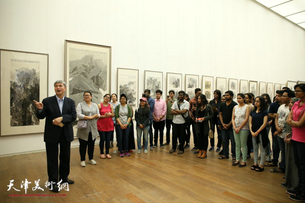申世辉在展览现场为喜欢中国画的留学生讲解作品。