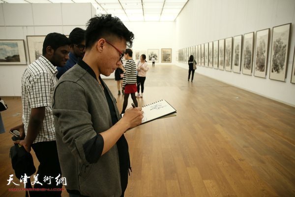 喜欢中国画的外国留学生在展览现场观赏作品。