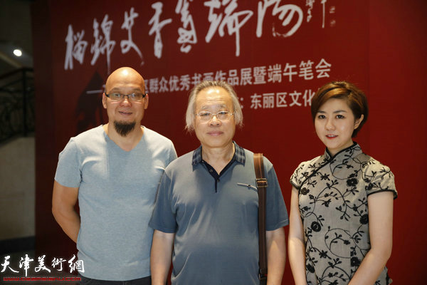 王金厚、王霞、王凤立在书画展现场。