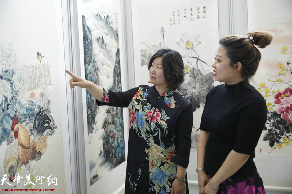 画家原卫妮、刘璐在观赏展出的作品。