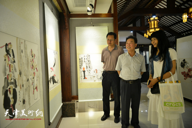 杨建国、潘津生、杨晓君在观看展品。