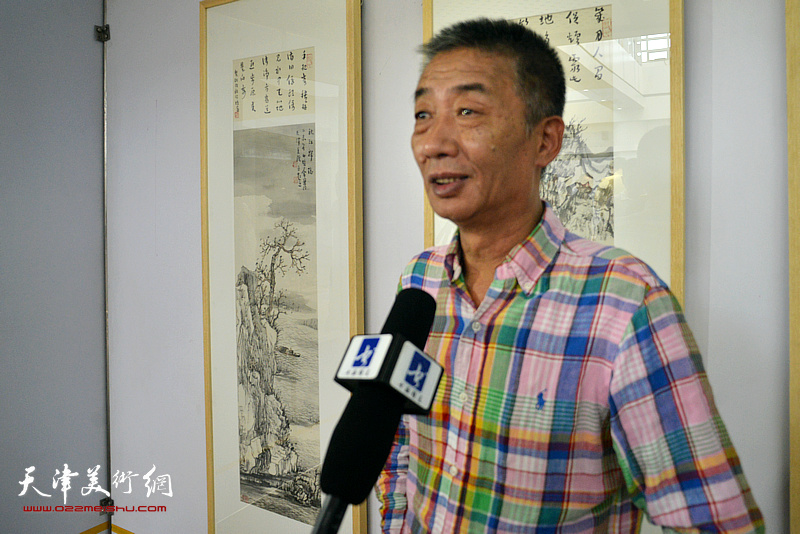 邓国源在画展现场接受媒体采访。