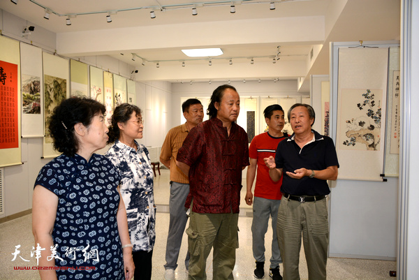 天津美术家协会副主席刘国胜观赏展品。
