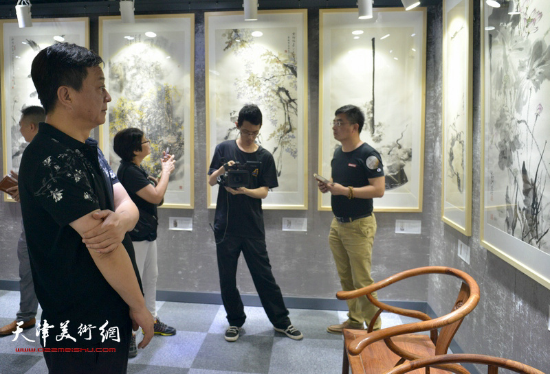 朱军在观看展出的天津美术学院教师作品。