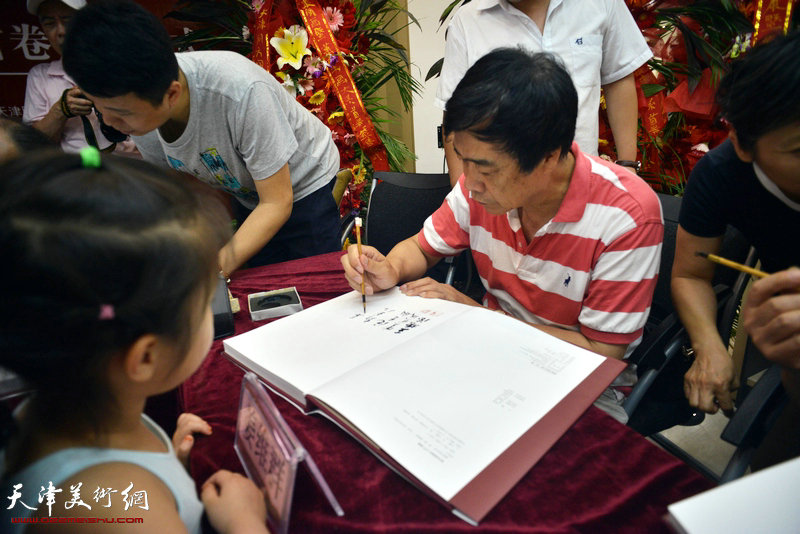 著名文化学者姜维群在《萧朗书画大系》首卷签售仪式上为读者签字。