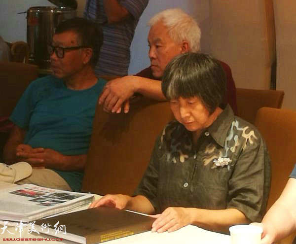 韩富华先生的夫人在阅读当日首发的《富华墨语三问-韩富华中国画集》。