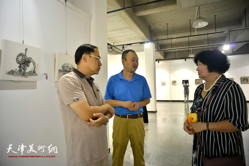 孟昭丽、李新禹、柴博森在画展现场交流。
