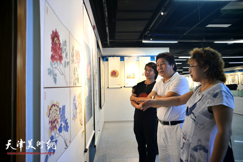 高学年与张春蕾、范宁在观赏展出的作品。