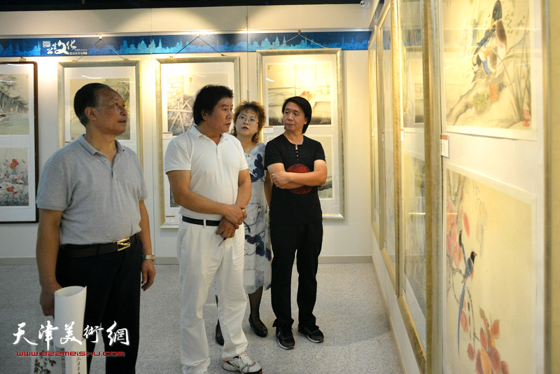 刘传光、高学年、张春蕾、范宁在观赏展出的作品。