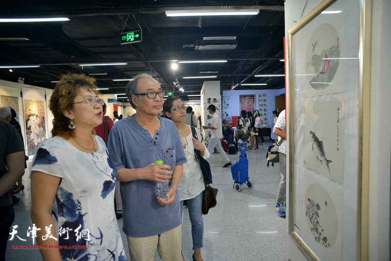 郭书仁与张春蕾在观赏展出的作品。