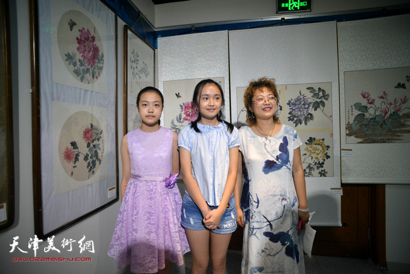 张春蕾与她的学生们在画展现场。