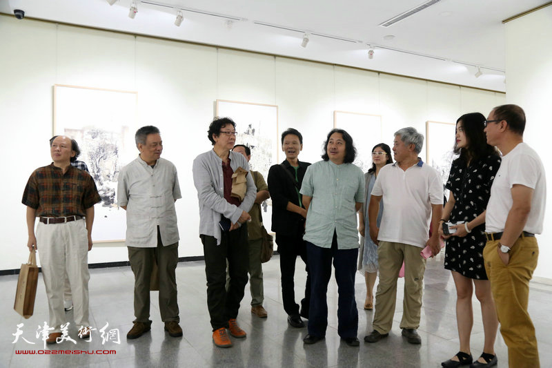 贾广健、晏平等参展画家在观赏展出的作品。