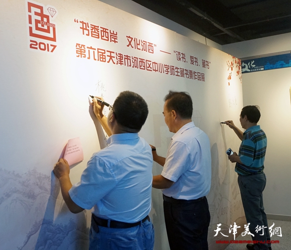 河西区文联主席怀远、河西区文化局副局长曲维和、中国美术家协会藏书票委员会常务副主席刘硕海在签到墙上书写祝福的话语