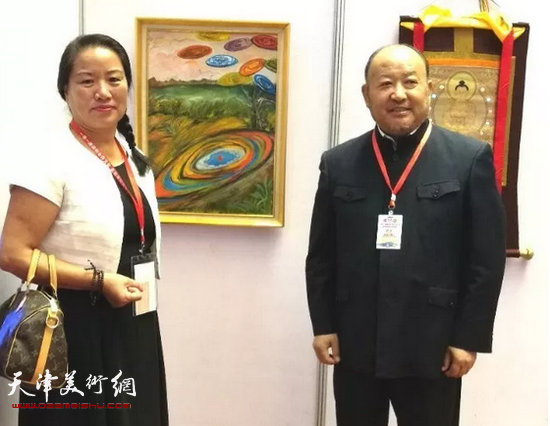 世界华人华侨华商联合总会梁海洋博士与李玉芬在画展现场。