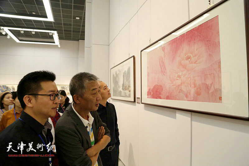 天津美术学院院长邓国源观摩展出的画作。