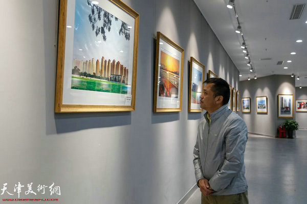 天津市摄影家协会秘书长包静在影展现场观展