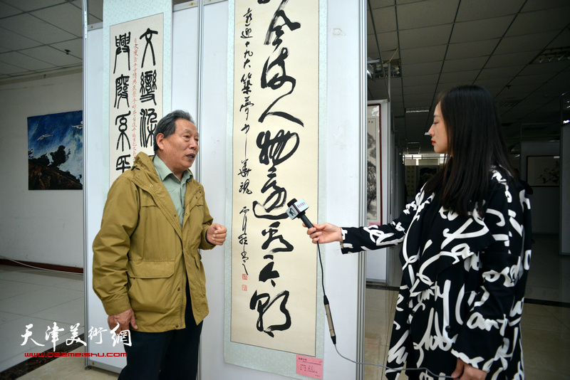 霍然在画展现场接受媒体采访。