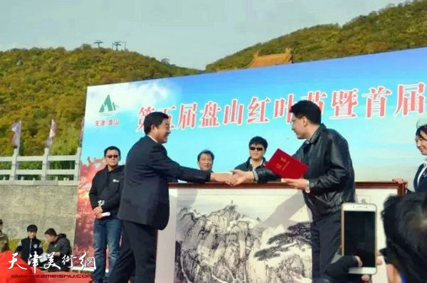 天津美术学院副院长郭振山向蓟州区捐赠李旭飞作品《盘山图》。