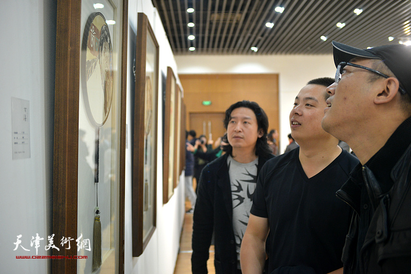 韩佳男、梁健、姚丽彬在观赏展出的作品。