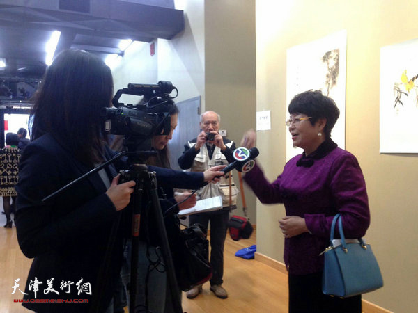 梦玉在画展现场接受当地媒体采访。