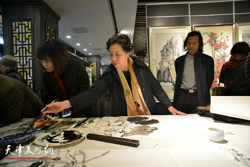 崔燕萍在画展现场挥毫创作。