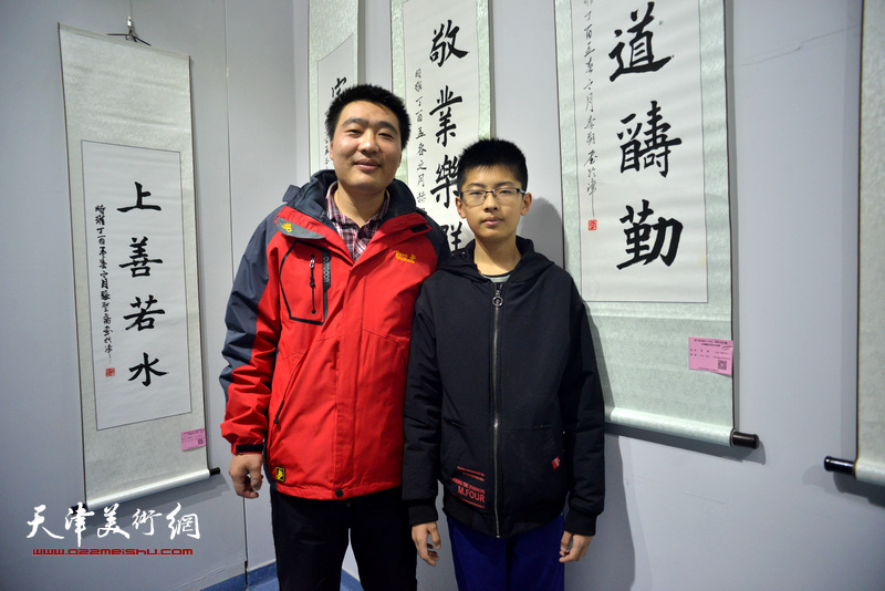 李朔与老师张磊在展出的作品前。