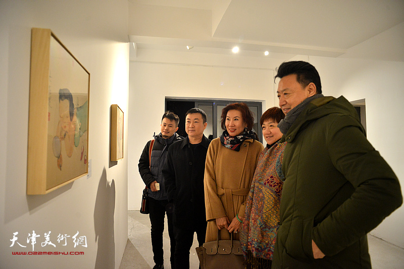 李旺与来宾在“众生集—李旺新水墨作品展”观赏展出的作品。
