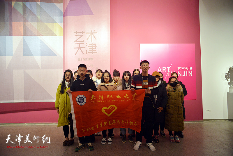 天津职业大学公共管理学院的青年志愿者在画展现场。