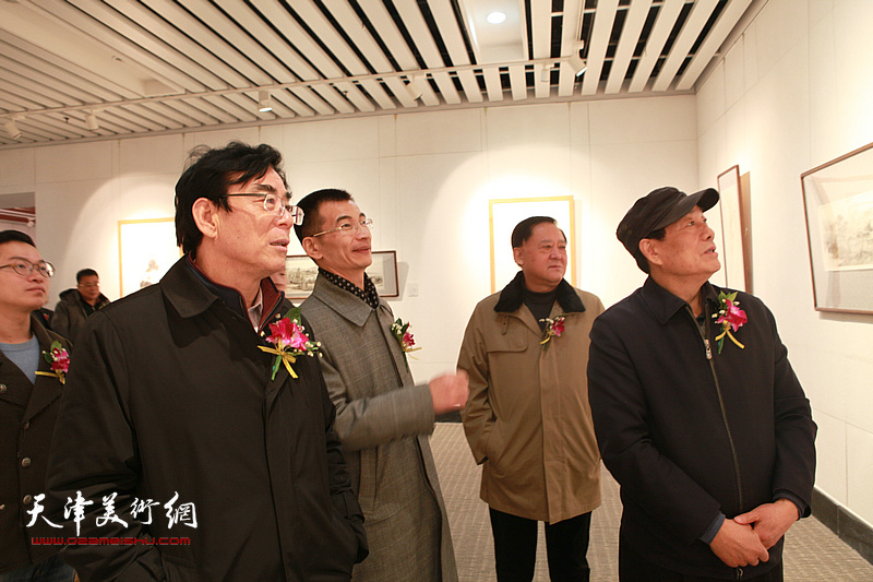 姜金军与领导、嘉宾在观赏展出的画作。