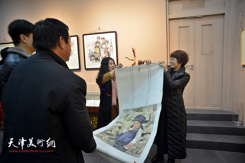 聂瑞辰在画展现场展示她的画作。