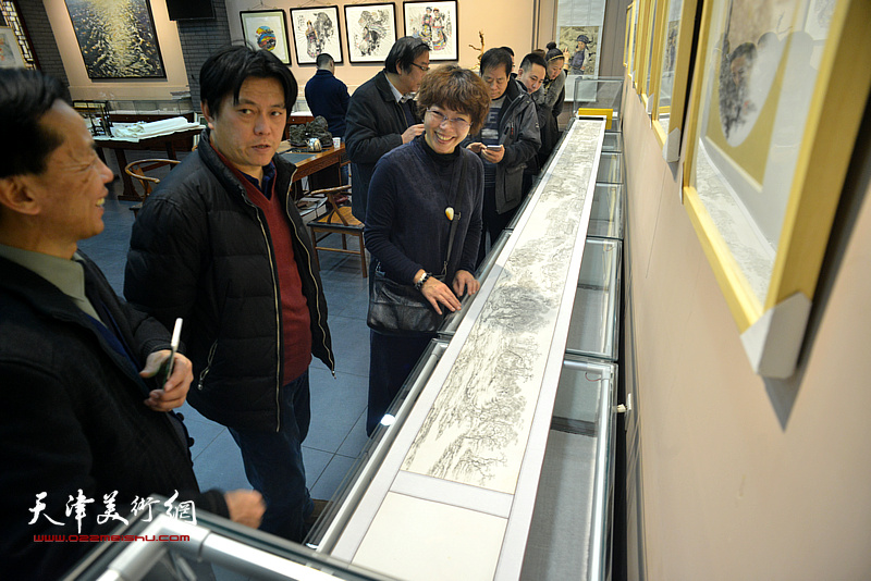 沧州市美术家协会秘书长杨贵玉在画展现场观赏展出的画作