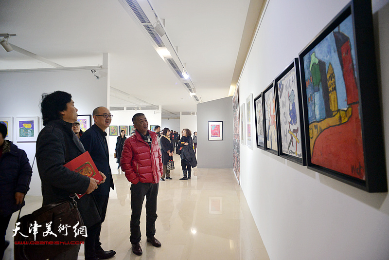 邓国源、王琨、马驰在观赏展出的画作。